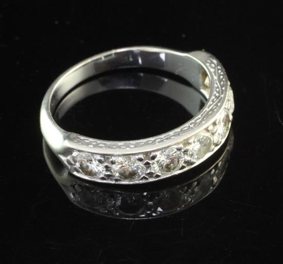 A white gold and seven stone diamond half eternity ring, size O.